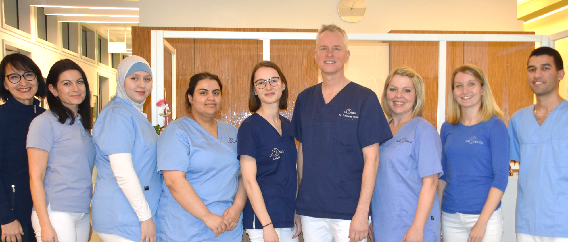 Ein modernes Behandlungszimmer mit grünen Sitzen und einer gemütlichen Einrichtung wird präsentiert.